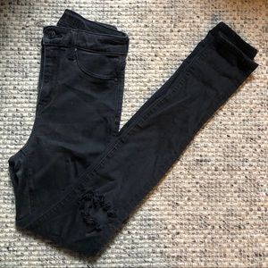 High-waisted black skinny jeans with ripped knees